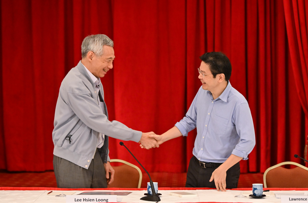 ·2022年4月16日，李显龙（左）与“接班人”黄循财握手。