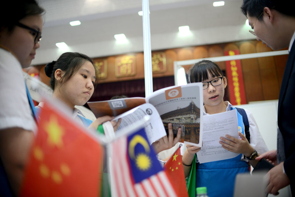 2019年3月6日，在马来西亚吉隆坡，马来西亚学生在“2019年留华高等教育展”上与中国高校代表交流。新华社发（张纹综摄）
