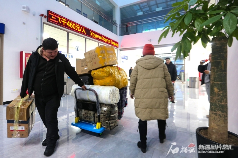 12月2日，旅客在乌鲁木齐陆港国际客运站准备装运采购的物资。