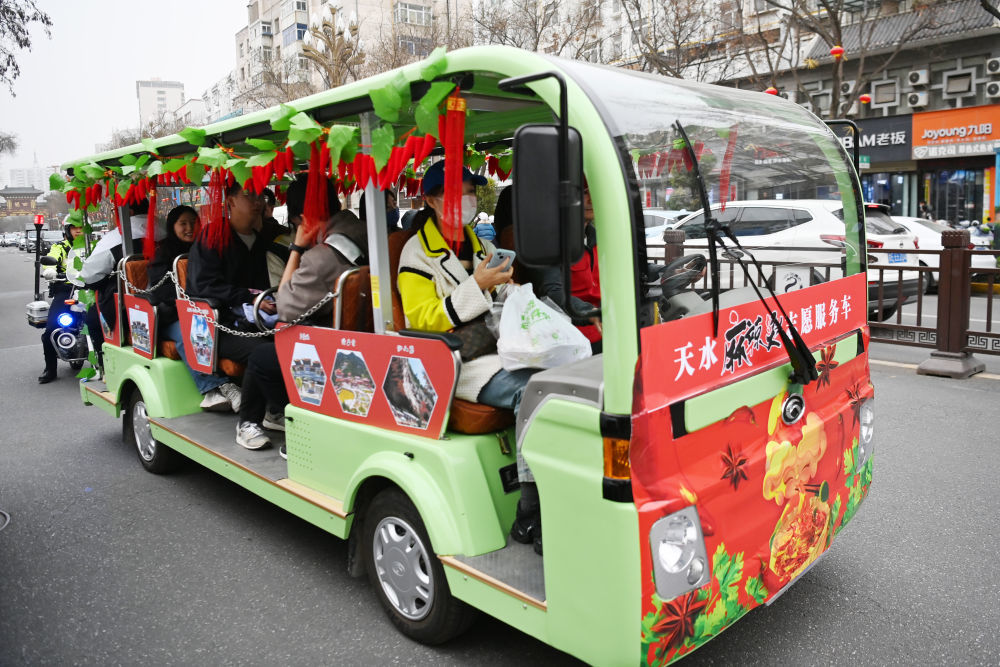 3月16日,在天水市秦州区,游客免费乘坐“天水麻辣烫志愿服务车”前往景区。新华社记者 范培珅 摄