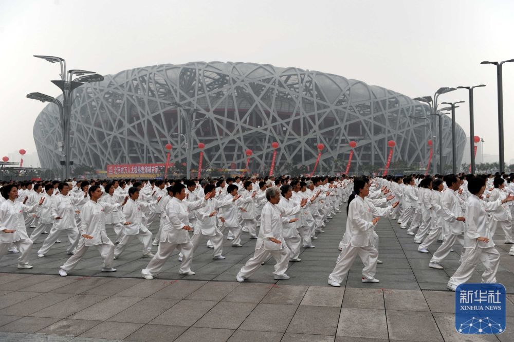 ↑2009年8月8日，爱好者们在“鸟巢”前打太极拳。新华社记者 郭勇 摄