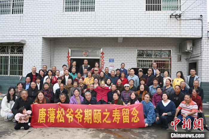 11月1日，在湖南浏阳市镇头镇北星村，身着红色上衣的百岁台湾老兵唐藩松和亲人们合影留念。　中新社记者 杨华峰 摄