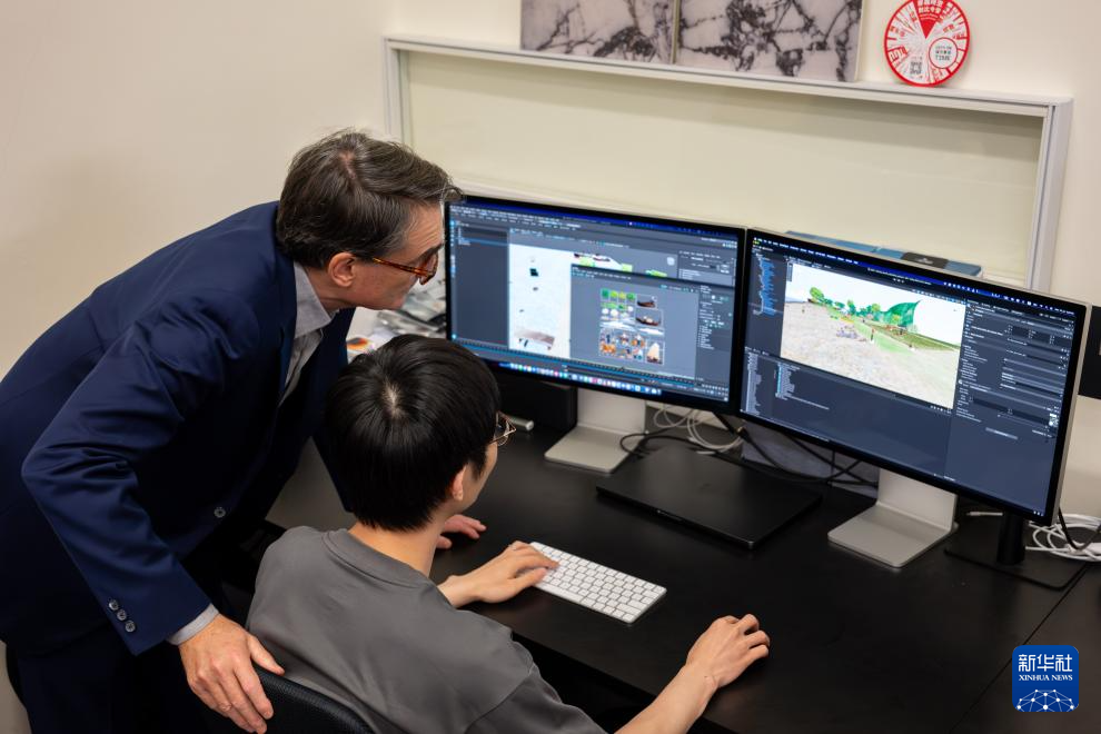 7月15日，艾朗宏（左）与创作团队成员交流。 新华社记者 朱炜 摄