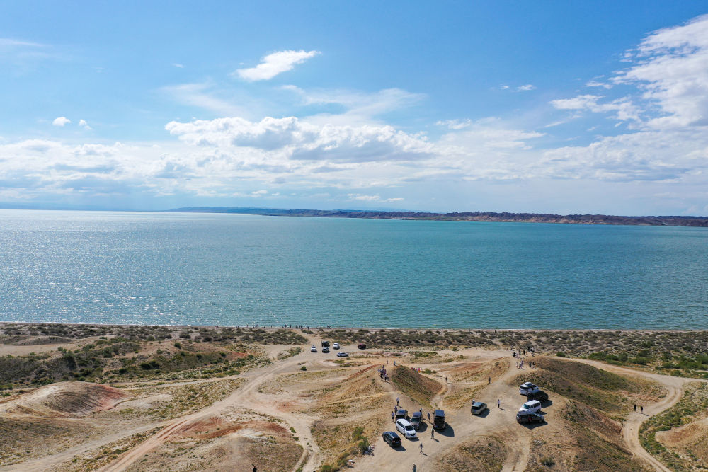 游客在新疆阿勒泰地区福海县乌伦古湖观光游览（7月21日摄）。