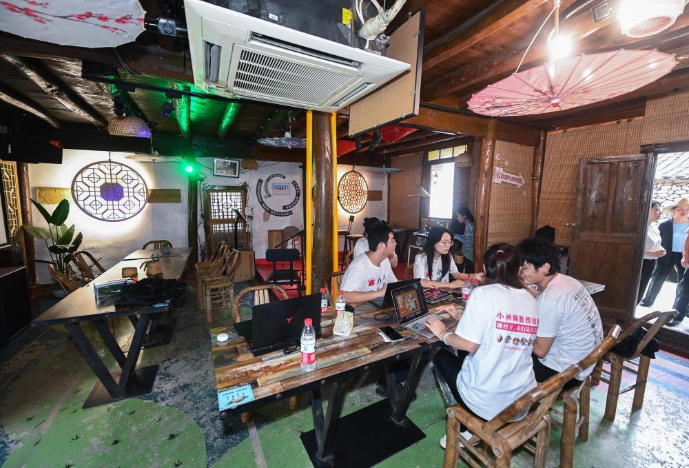 2023年8月11日，高校艺术院系的大学生们在宁波市宁海县葛家村的特色酒吧内讨论村落艺术改造提升的设计方案。新华社记者 徐昱 摄
