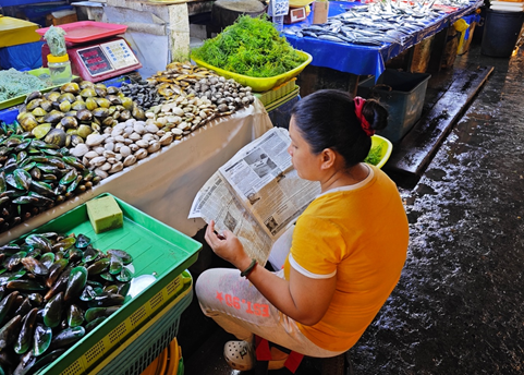 在远离南海争议地区的菲律宾棉兰老岛达沃市，海鲜市场中的商户也在关注着菲海岸警卫队在南海争议地区的行动（拍摄：樊巍）