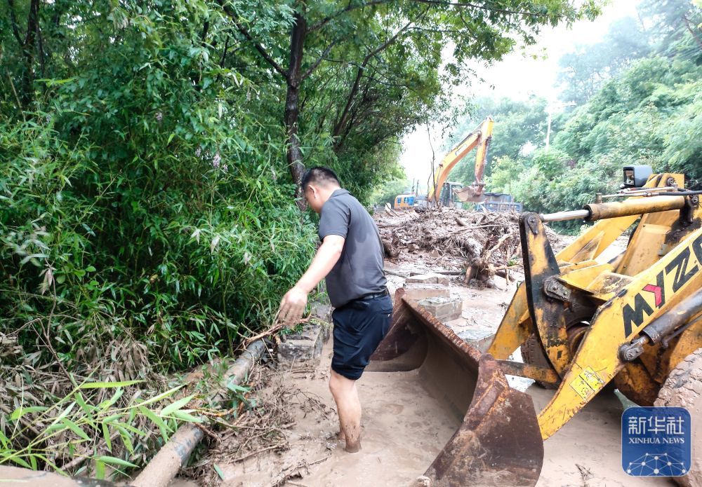 ↑6月20日，在黄山市屯溪区，工作人员清理塌方路段。新华社发（吴丹摄）