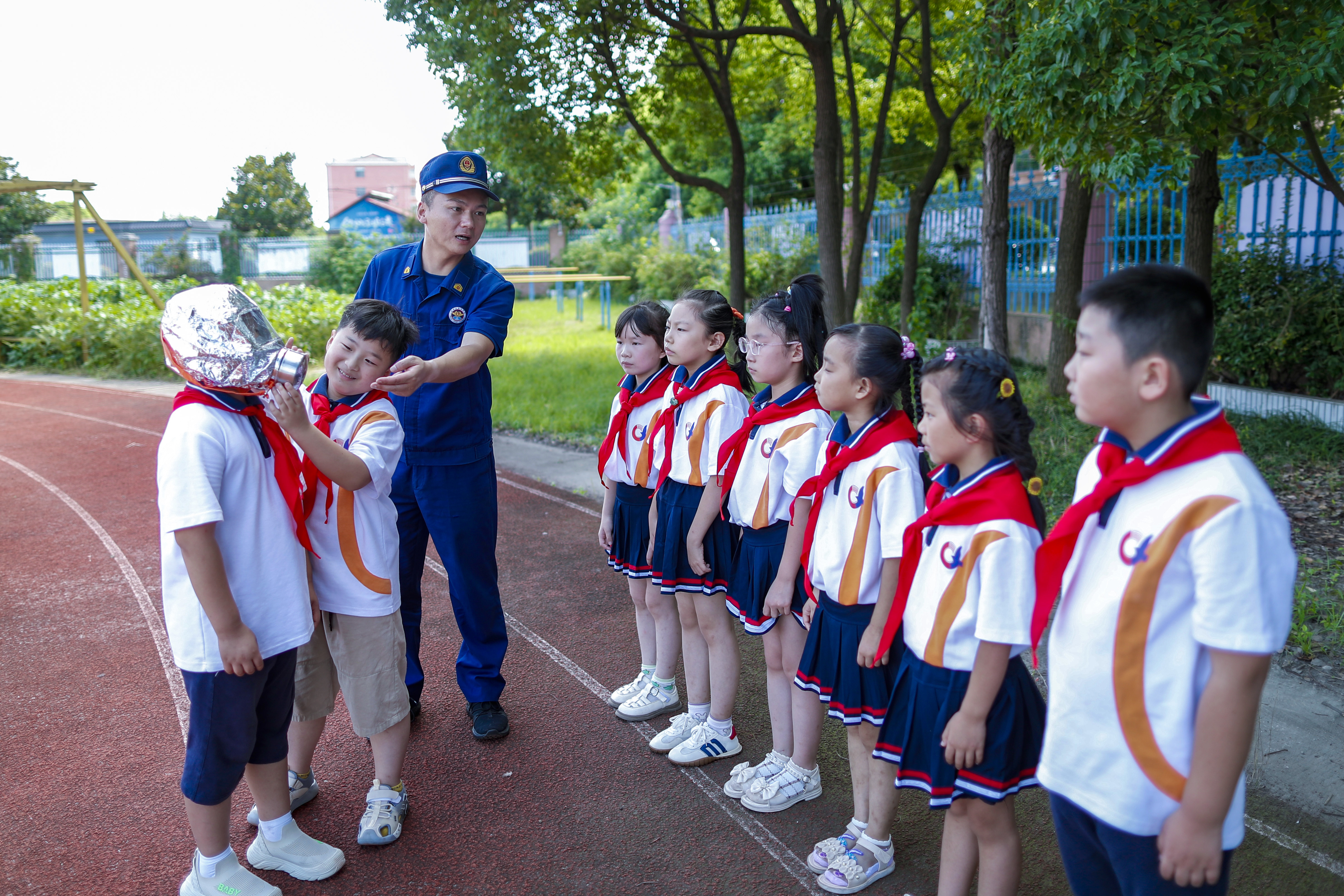 2024年9月3日，在江苏省兴化市陈堡中心小学，兴化市消防救援大队消防员为学生介绍防毒面具安全使用方法。新华社发（周社根摄）