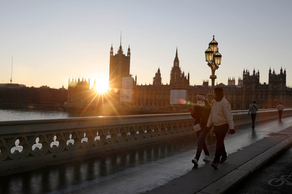 人们在英国伦敦横跨泰晤士河的威斯敏斯特桥上行走。