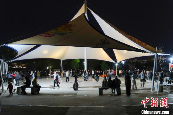 4月26日晚，在拉萨柳梧中心公园跳锅庄舞的市民，现场热闹非常。　中新社记者 江飞波 摄