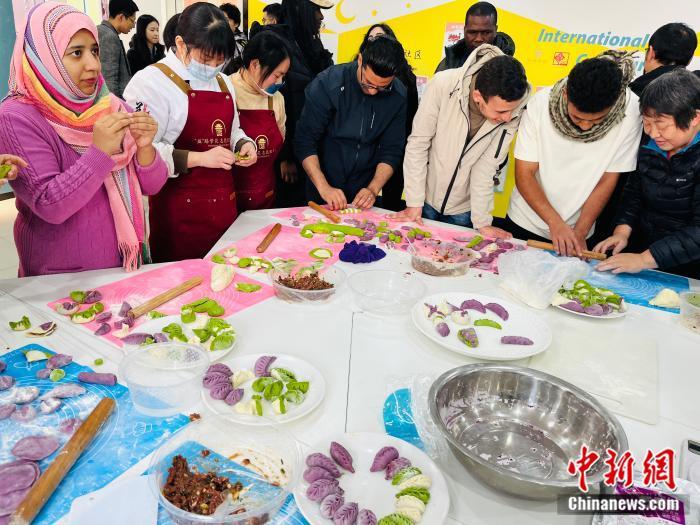 义乌鸡鸣山社区组织中外居民包饺子活动。(中新网 赵丽 摄)