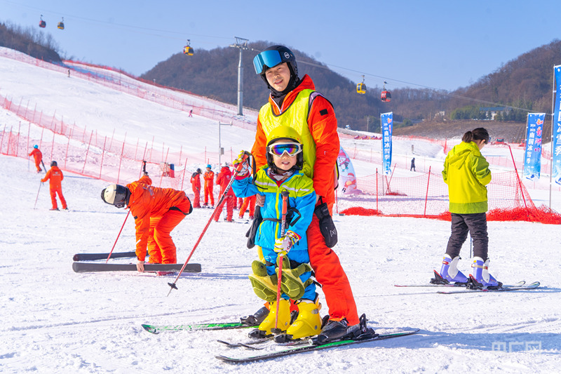 小朋友在教练员的指导下学习滑雪（央广网见习记者邓子依 摄）