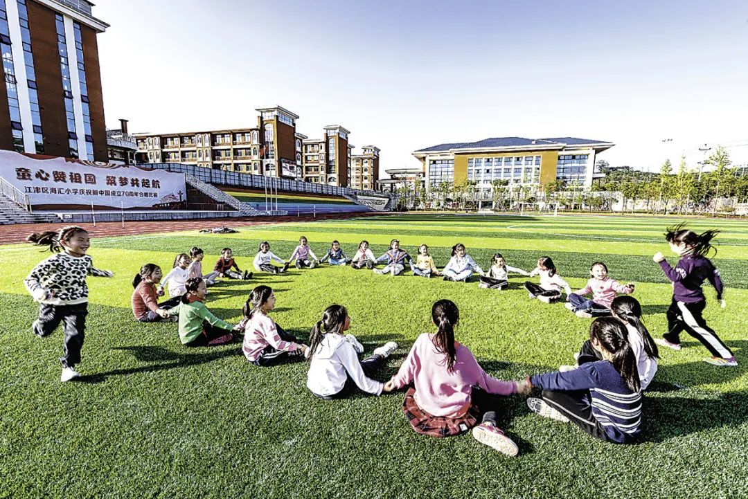 重庆市江津区海汇小学的孩子们在操场上愉快地做游戏。