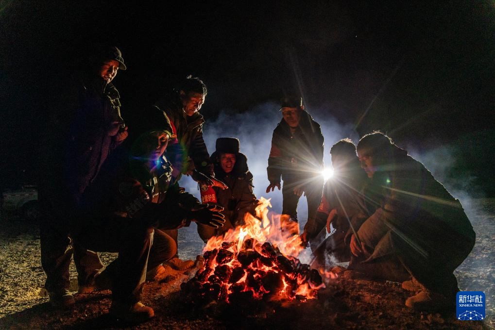 5月10日，野生动物专业管护队员在宿营地用野牦牛粪烤火取暖。新华社记者 丁增尼达 摄
