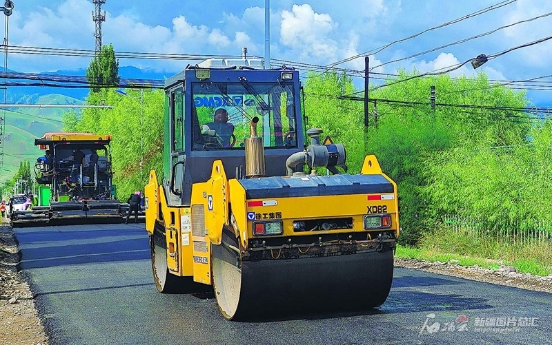 7月29日，工人在通往新源县坎苏镇阔克托别村的农村公路建设现场摊铺沥青。今年，新源县实施农村公路建设项目5个，建设里程94.845公里，涉及4个乡镇，目前已完成工程量的75%。 张文庭摄