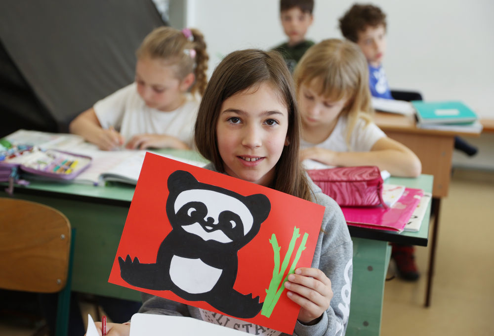 匈中双语学校三年级学生宝怡展示自己的大熊猫形象美术作品（2024年5月3日摄）。