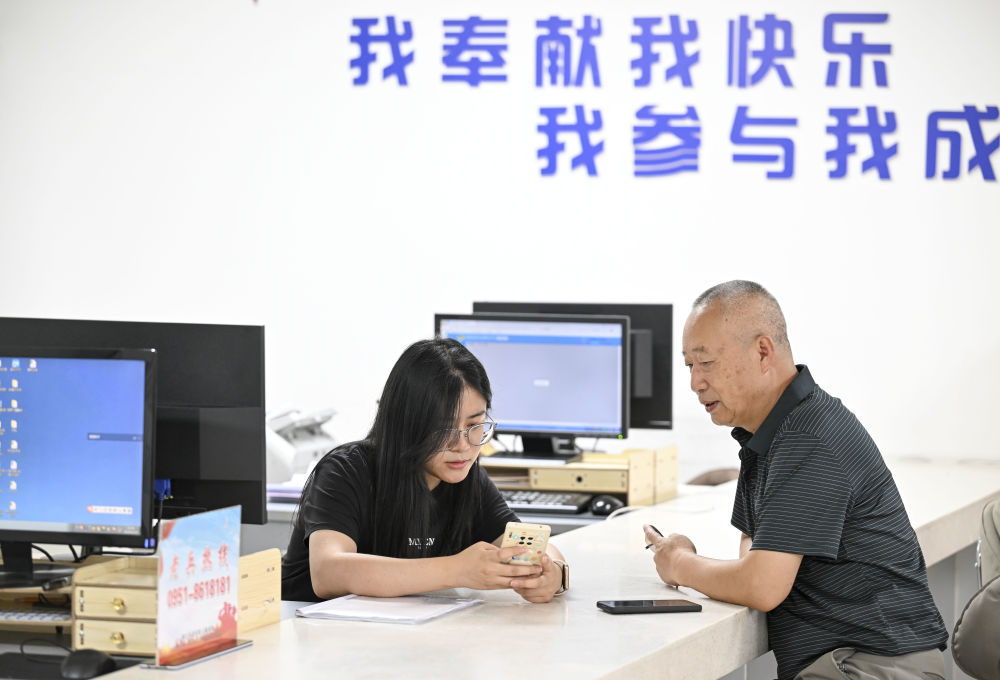 6月20日，在长城花园社区党群服务中心，工作人员帮助居民办理业务。