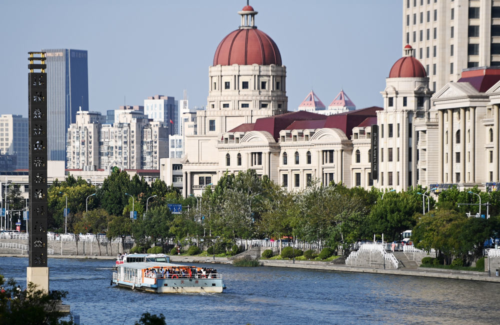 游客乘坐海河游船游览天津城市风光。
