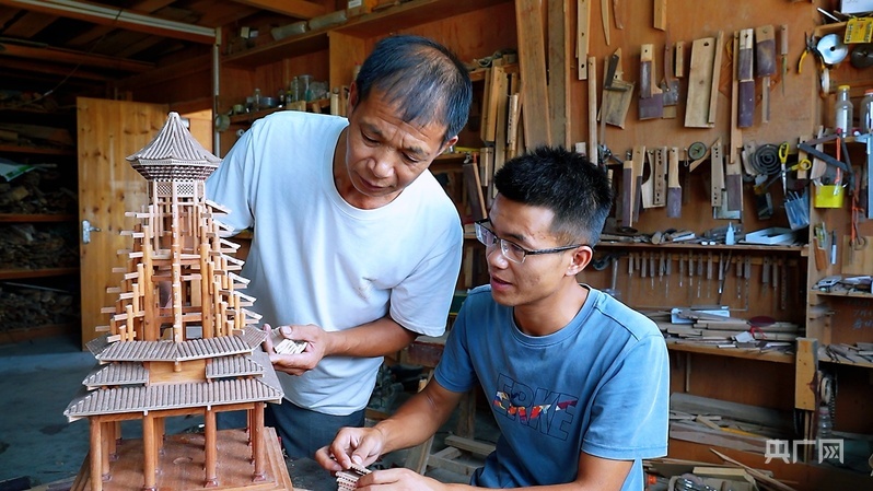 陆根卫和儿子陆贵朋在制作鼓楼模型（央广网发 张明辉 摄）