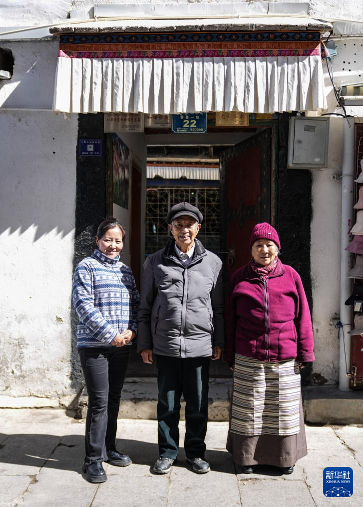 洛桑贡布（中）和大儿媳央金（左）、老伴次仁白姆在家门口前合影（3月27日摄）。新华社记者 晋美多吉 摄