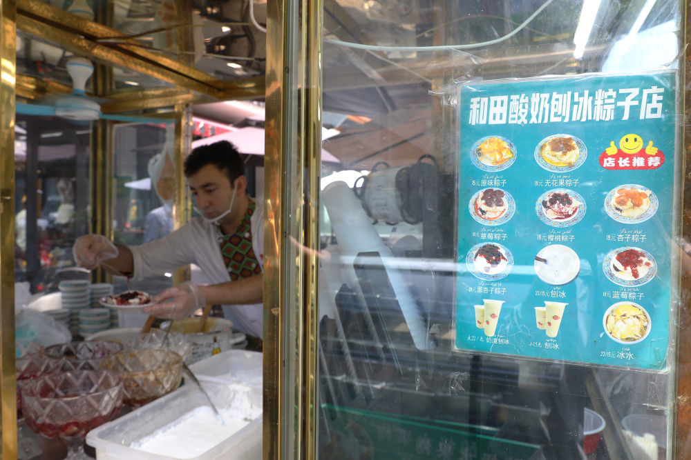 在北京一家餐厅，工作人员为顾客制作酸奶粽子。