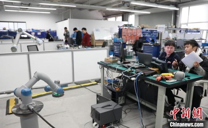 人工智能让中国制造业从“追赶者”变身“领跑者”。图为中科新松的工作人员正在对机器手臂进行位置标定。　张亨伟 摄