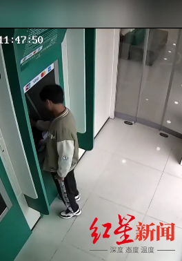 ▲邱某在ATM机上取钱