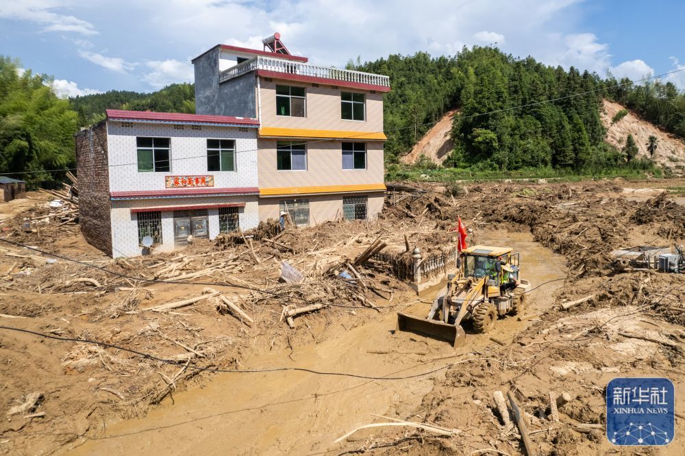 ↑8月7日，在资兴市州门司镇燕窝村，抢险队伍在疏通道路（无人机照片）。新华社记者 陈思汗 摄