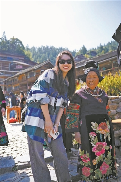 重庆市民杨韫韬(左)到贵州凯里“奔县游”时与当地住户合影