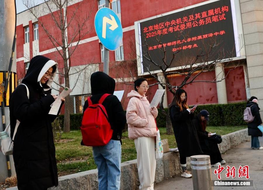 12月1日,北京首都师范大学附属丽泽中学初中部国考考点外,考生抓紧时间复习。中新社记者 易海菲 摄