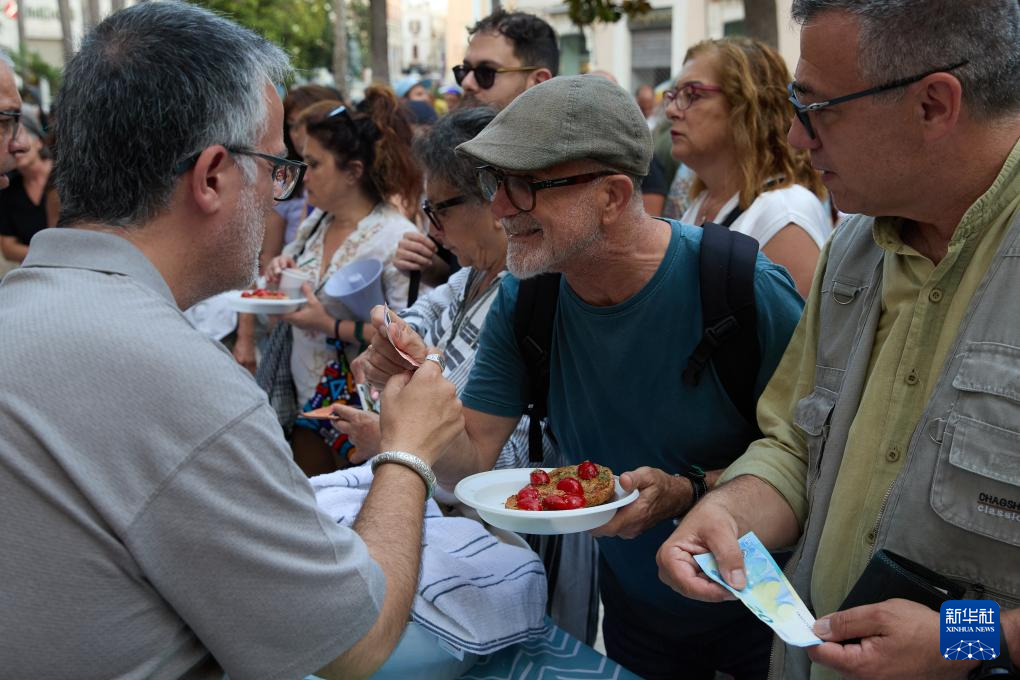 6月13日，民众在意大利布林迪西参加集会现场的义餐活动。新华社记者 孟鼎博 摄