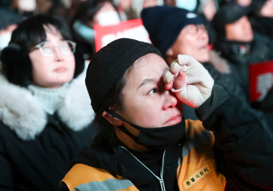 ▲12月7日，在位于韩国首尔的国会附近，民众观看总统尹锡悦弹劾案表决结果 图据新华社