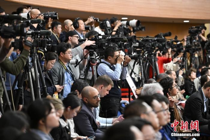 3月6日，十四届全国人大二次会议举行记者会，图为中外记者在现场采访。中新社记者 何蓬磊 摄