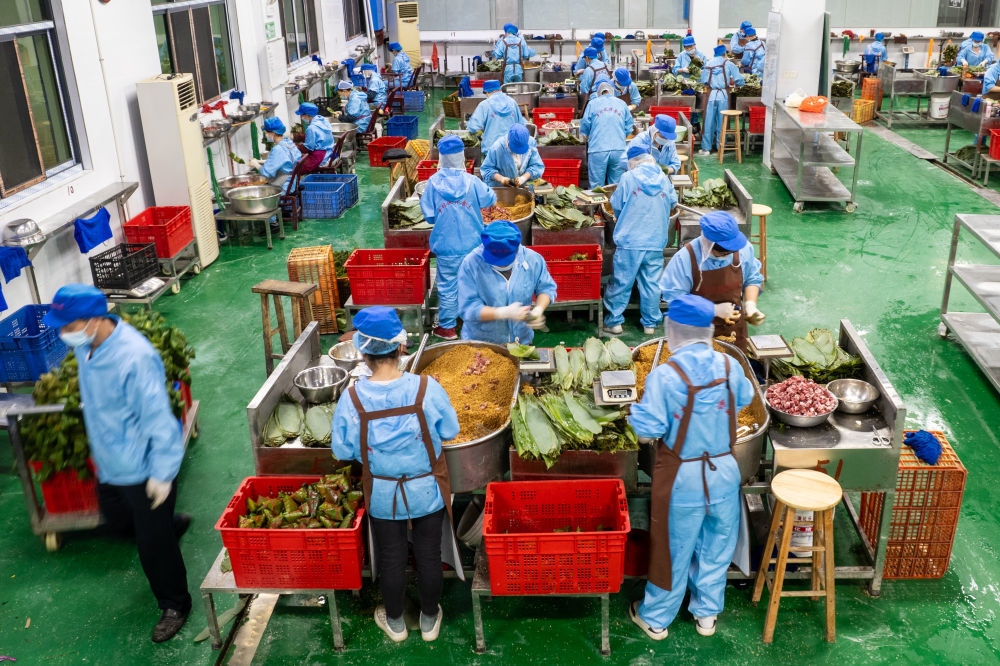 6月5日，在浏阳市关口街道道源湖村一家粽子生产车间，工人在包粽子（无人机照片）。