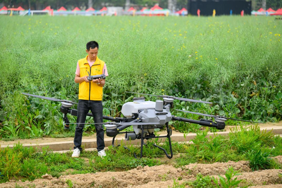 △ 2024年3月18日，广东省东莞市石碣镇掀起春耕生产热潮。图为一名工作人员正在操作无人机。