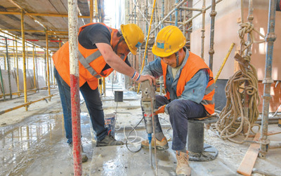 在埃及新行政首都中央商务区施工现场，中国工程师指导埃及“鲁班学院”学员施工作业。黎炳宏摄