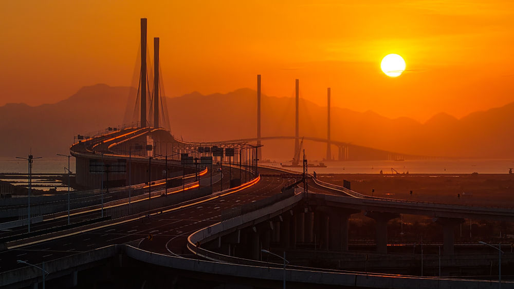 夕阳下的高栏港大桥（左侧双主塔）和黄茅海大桥（右侧三主塔）（2024年12月4日摄，无人机照片）。新华社记者 刘大伟 摄