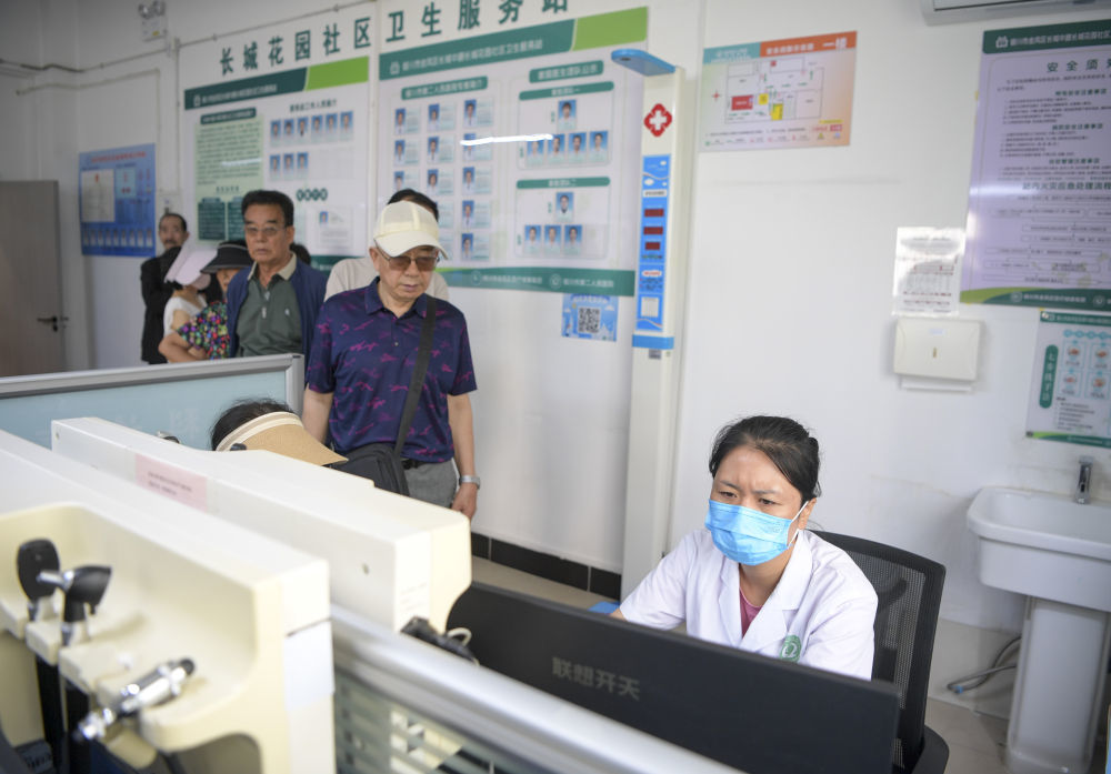 6月20日，长城花园社区卫生站的工作人员为居民登记医疗信息。