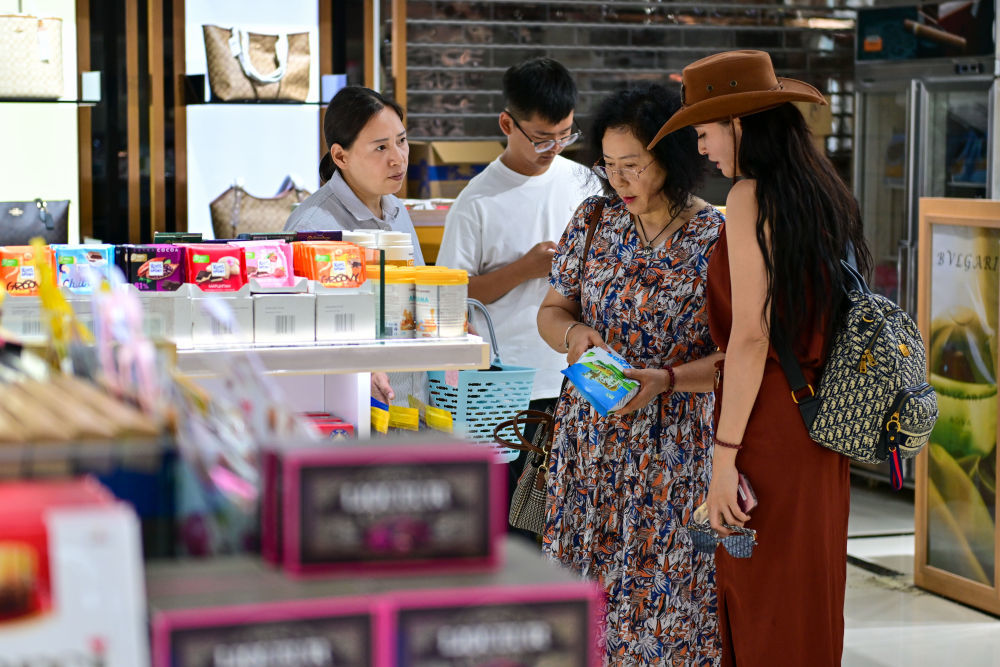 在中哈霍尔果斯国际边境合作中心，游客在免税店挑选商品（7月26日摄）。