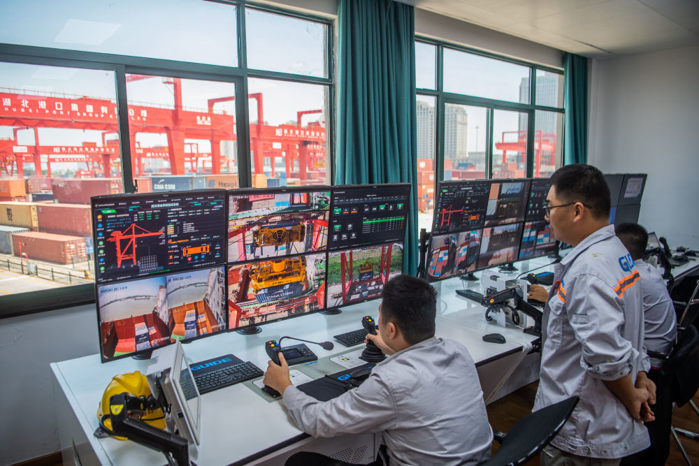 在武汉阳逻港，工作人员在远程操作机械设备吊装集装箱（2023年7月5日摄）。新华社记者 伍志尊 摄