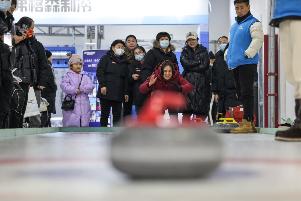 ↑2023年12月16日，市民在首届呼伦贝尔&middot;海拉尔冰雪产品冬季展销会上体验冰壶。新华社记者 王楷焱 摄