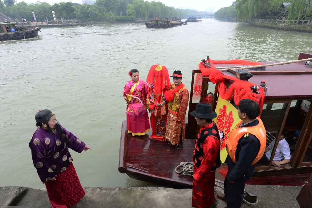2014年4月26日，一位新郎在浙江杭州北新关码头迎娶乘船而来的新娘。