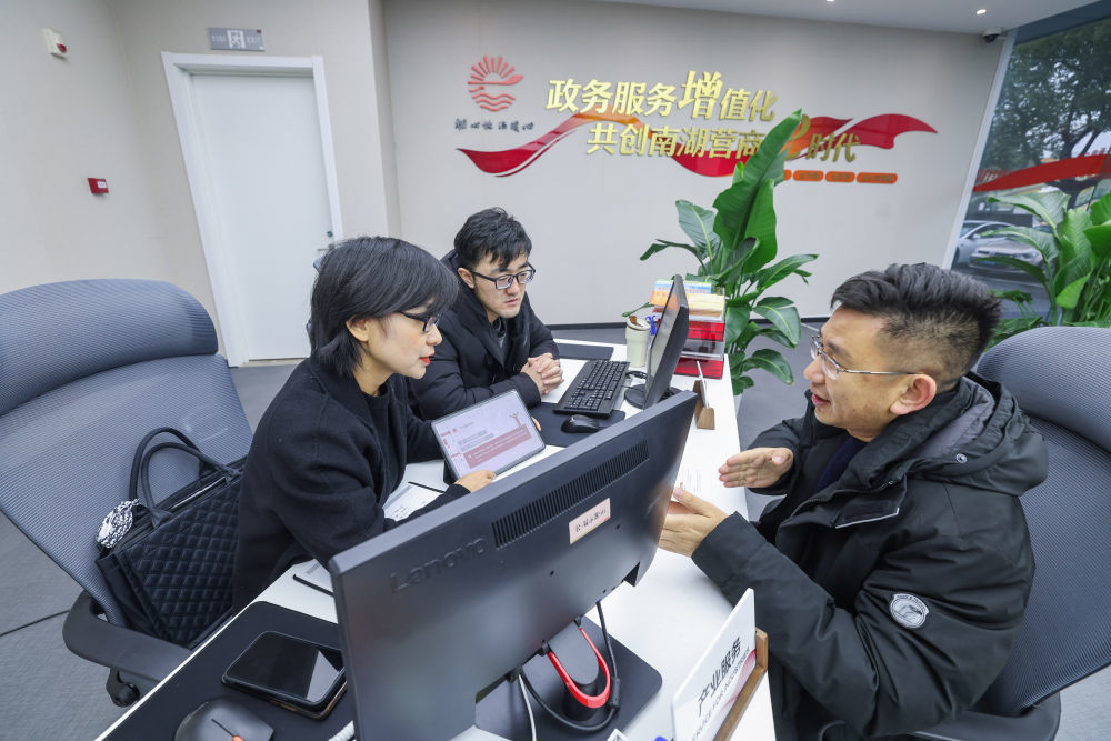2024年2月29日,在浙江省嘉兴市南湖区企业综合服务中心内,产业板块首席服务专员在接待办事企业人员(右)。新华社记者 徐昱 摄