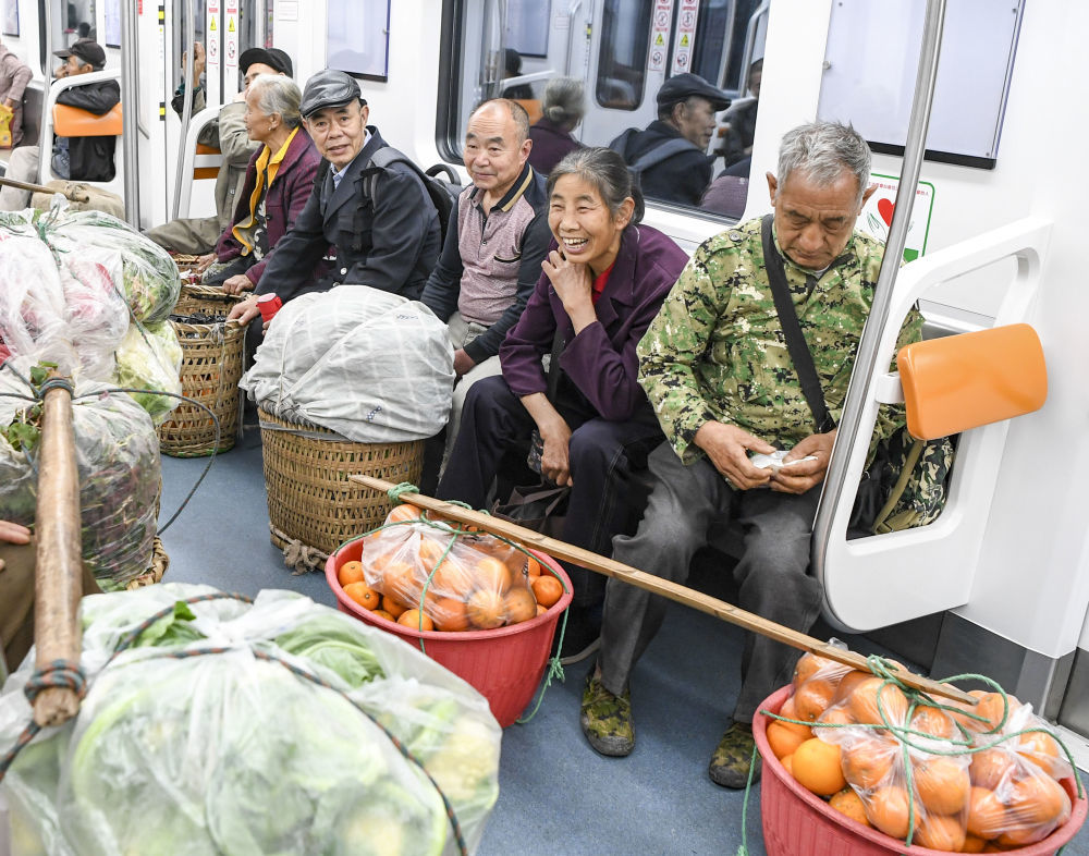 ↑3月27日清晨，菜农乘坐被称为“背篓专线”的重庆轨道交通4号线，前往重庆城区的菜市场售卖农产品。新华社记者 王全超 摄