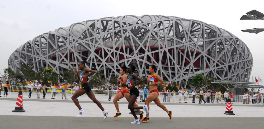 ↑2008年8月17日，选手们在北京奥运会女子马拉松比赛中跑过“鸟巢”。