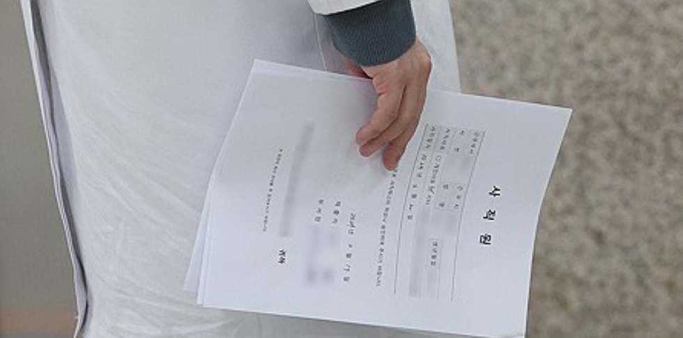 2月19日,韩国一家医院的医生手持辞职报告。(图/韩联社)