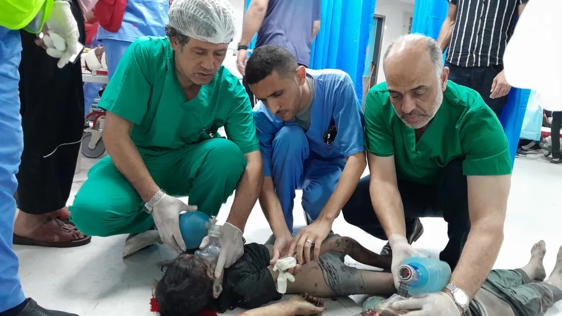 阿尔-伯什（左）生前在加沙医院救治受伤儿童 图源：加沙卫生部