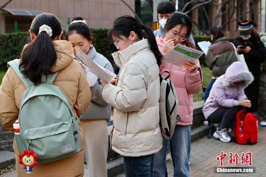 12月1日,北京首都师范大学附属丽泽中学初中部国考考点外,考生抓紧时间复习。中新社记者 易海菲 摄