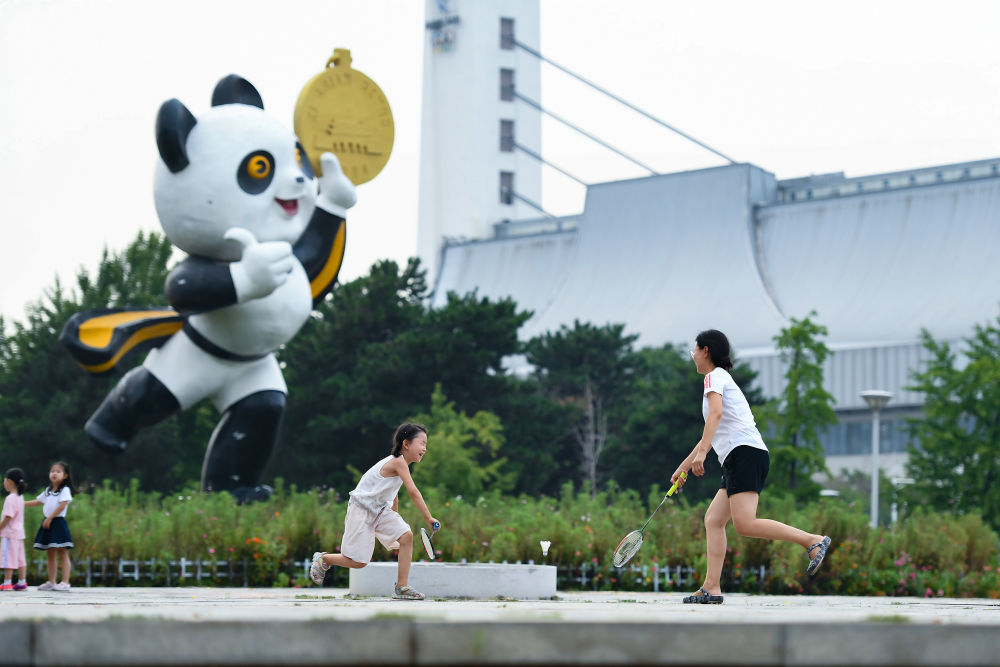 2023年8月20日,市民在位于北京的国家奥林匹克体育中心小广场上打羽毛球。国家奥林匹克体育中心是我国第一个承办大型综合性国际体育赛事的体育场馆群,为1990年北京亚运会而建。新华社记者 陈钟昊 摄