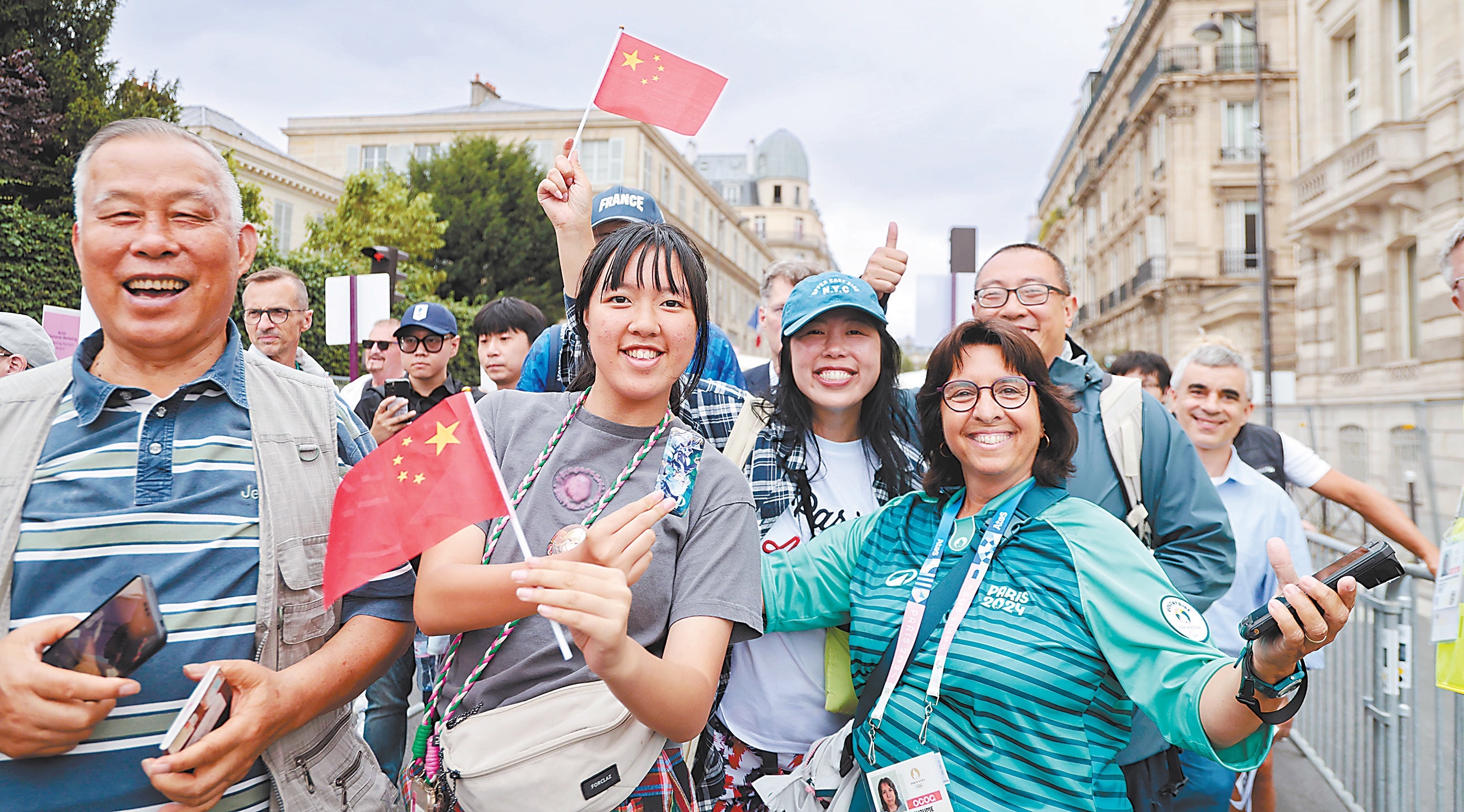 当地时间26日,第33届夏季奥运会开幕式在法国巴黎举行。图为检票入场时挥舞中国国旗的观众和志愿者合影。李昊摄